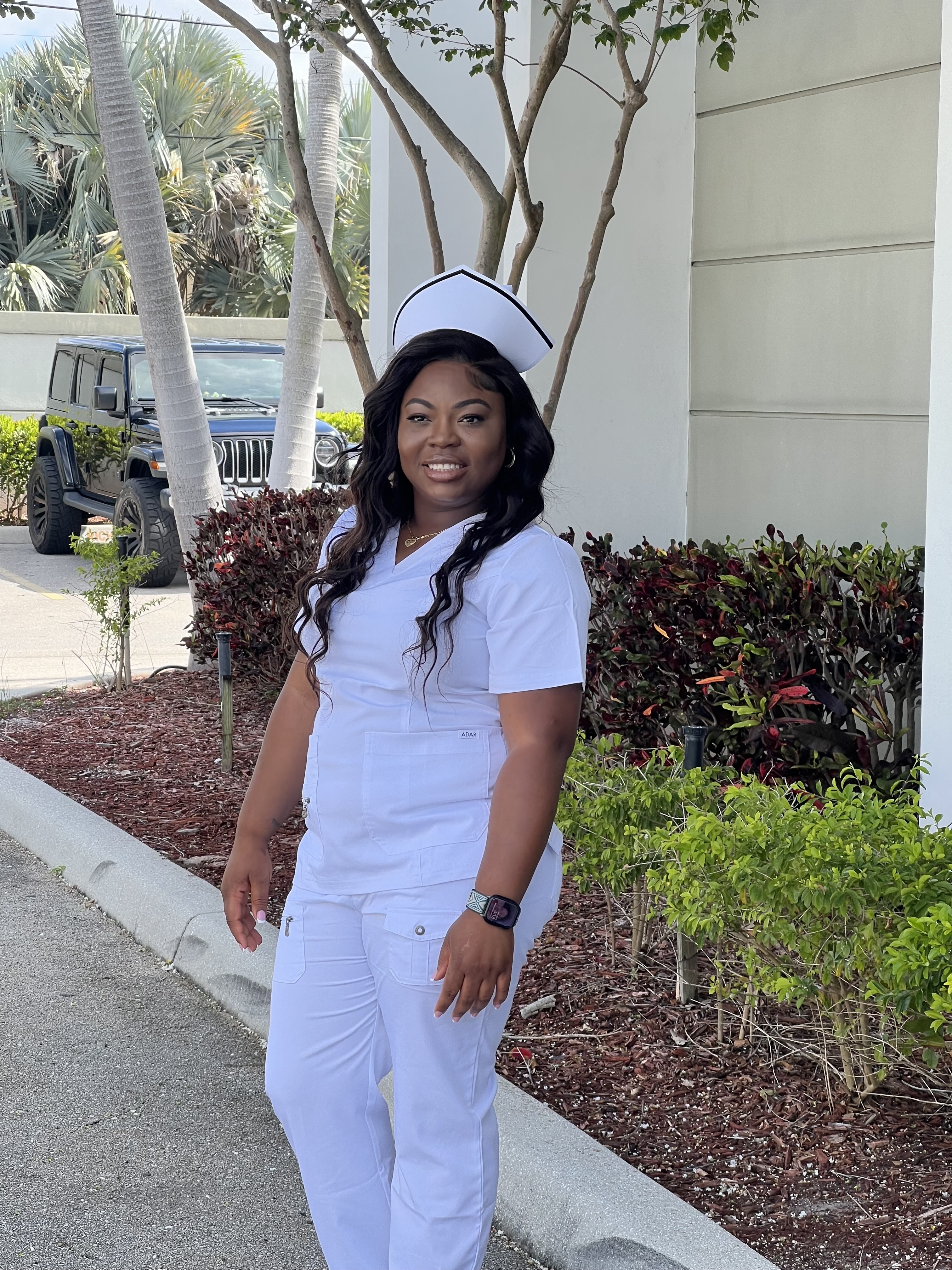Woman in nurses uniform posing happily outside